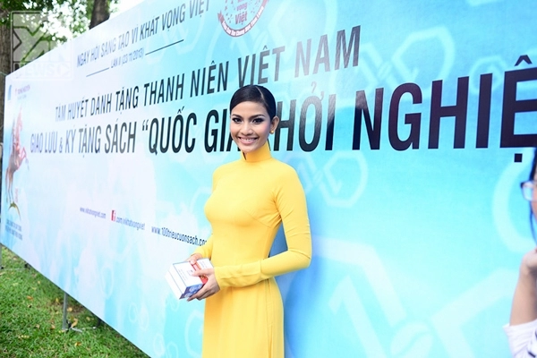 Á hậu trương thị may giản dị với áo dài vàng rực