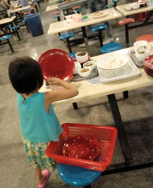 Bé 6 tuổi dọn thức ăn thừa cho sinh viên gây tranh cãi