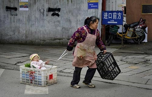 Em bé hàng ngày nằm trong giỏ rau cùng bà đi bán hàng