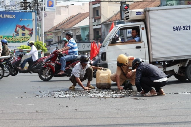 Hai csgt đội nắng giúp dân gom cá đổ ra đường