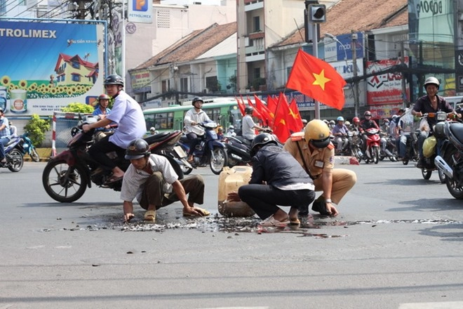 Hai csgt đội nắng giúp dân gom cá đổ ra đường