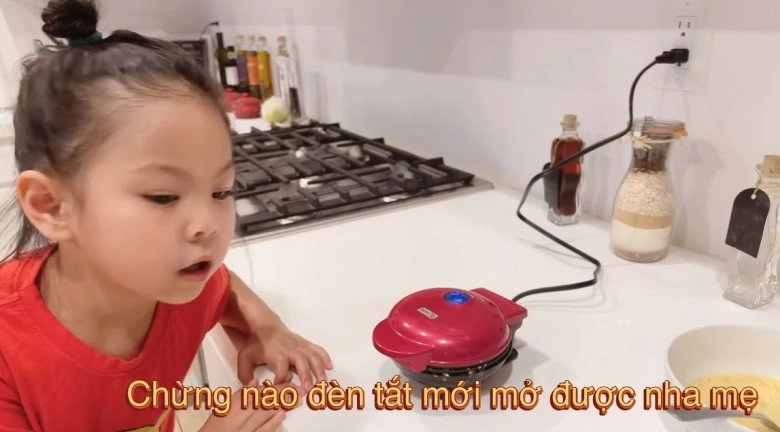 Con gái đáng yêu của búp bê thanh thảo làm bánh cho mẹ bố gốc hoa ân cần phía sau